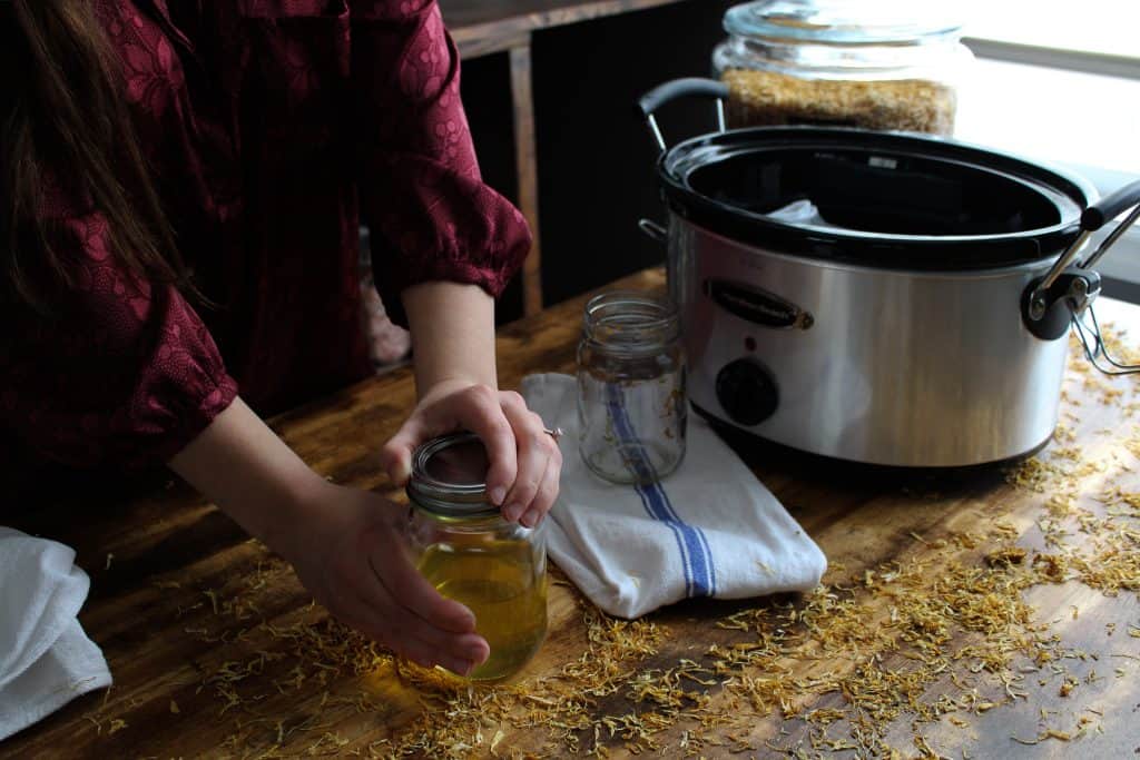 a lid is secured on the jar of finished herb oil