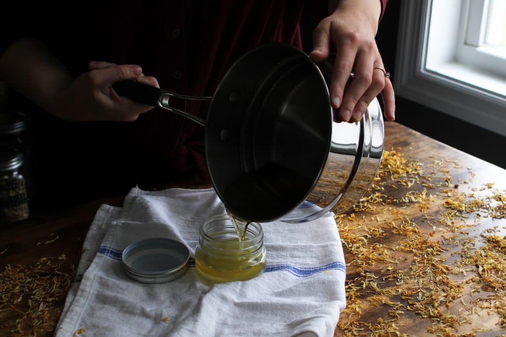 pouring salve into a small glass jar