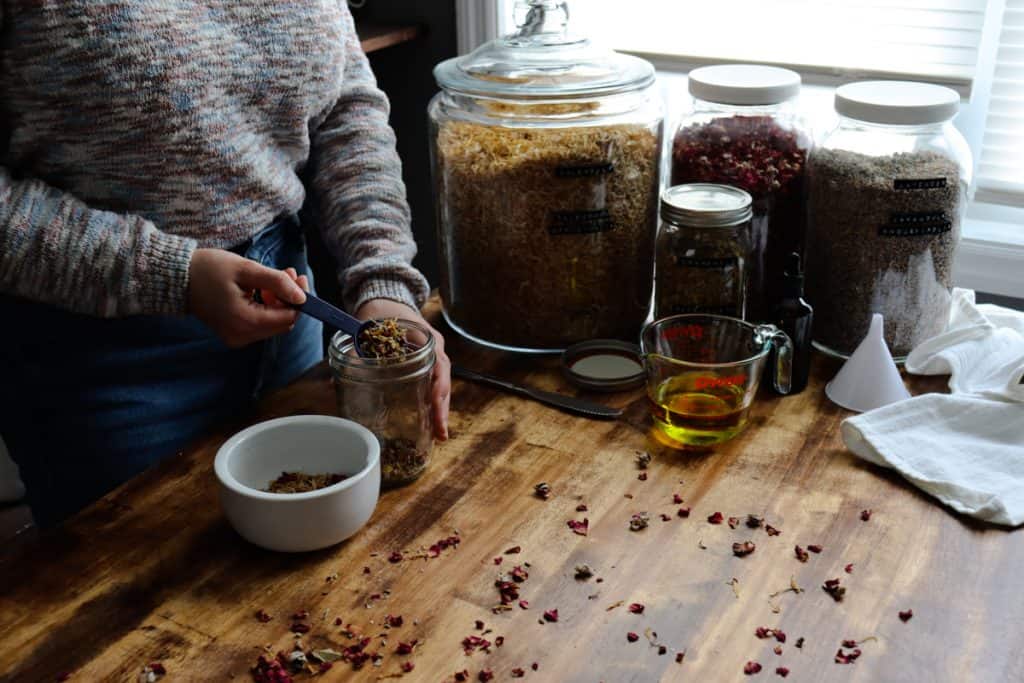 measuring out and transferring the herbs into the jar