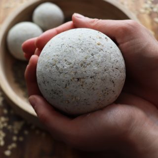 a woman's hands holding a bath bomb