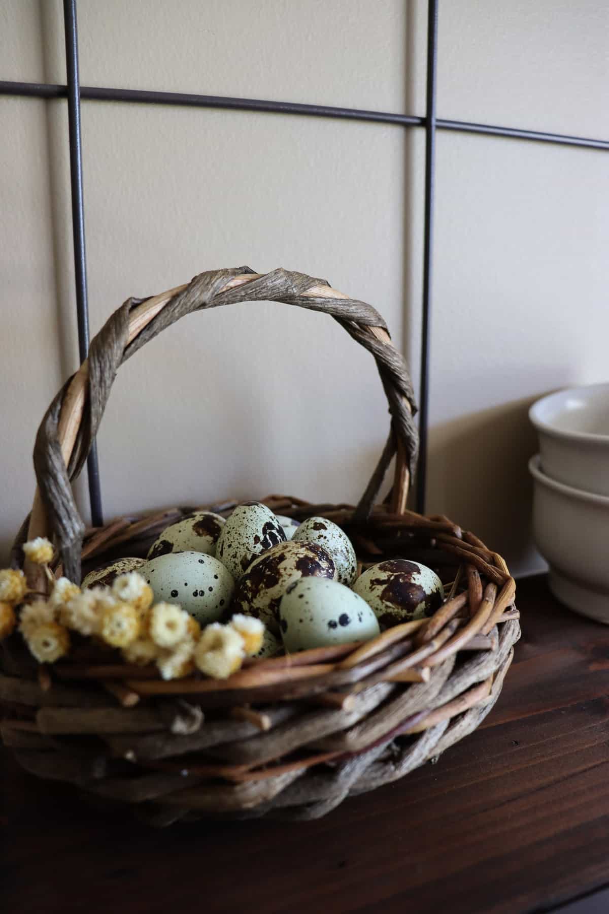 blown eggs in a basket with dried flowers on a shelf