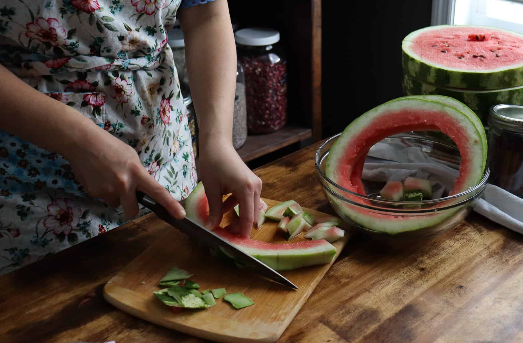 cutting off the outer layer of the watermelon rind