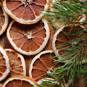 orange slices next to pine branches on the kitchen table
