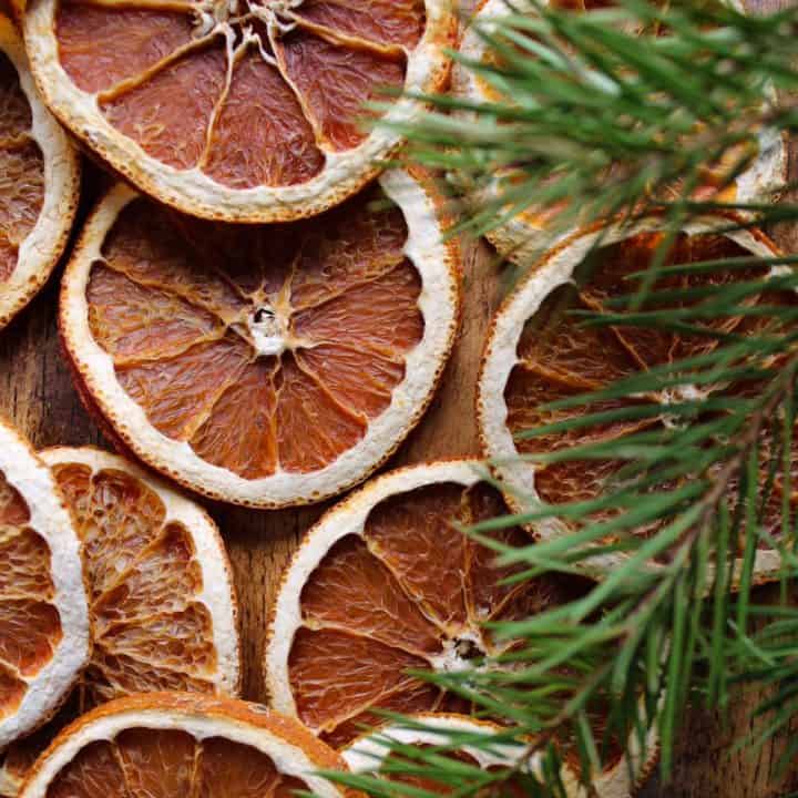 orange slices next to pine branches on the kitchen table