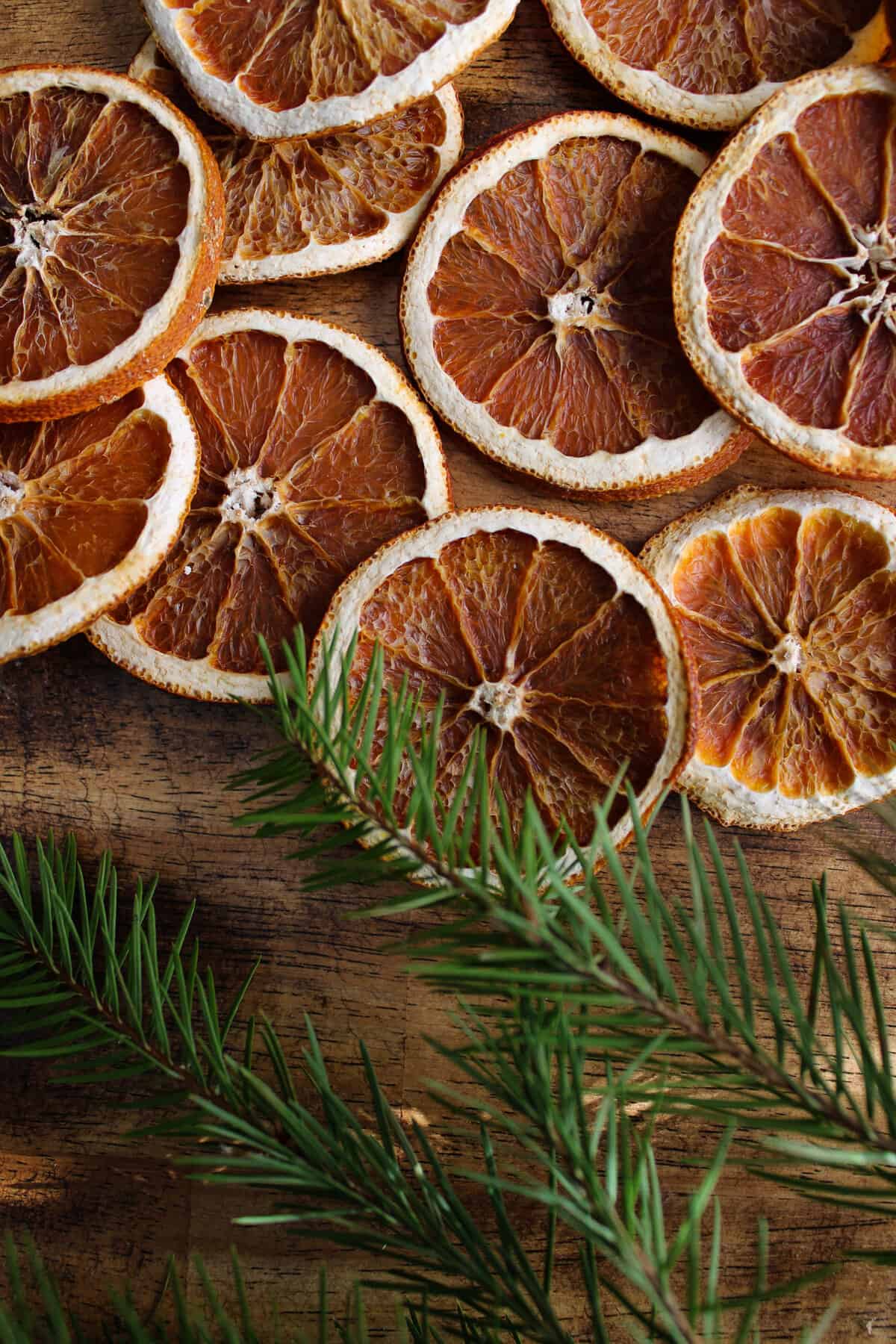 orange slices on the table next to pine branches