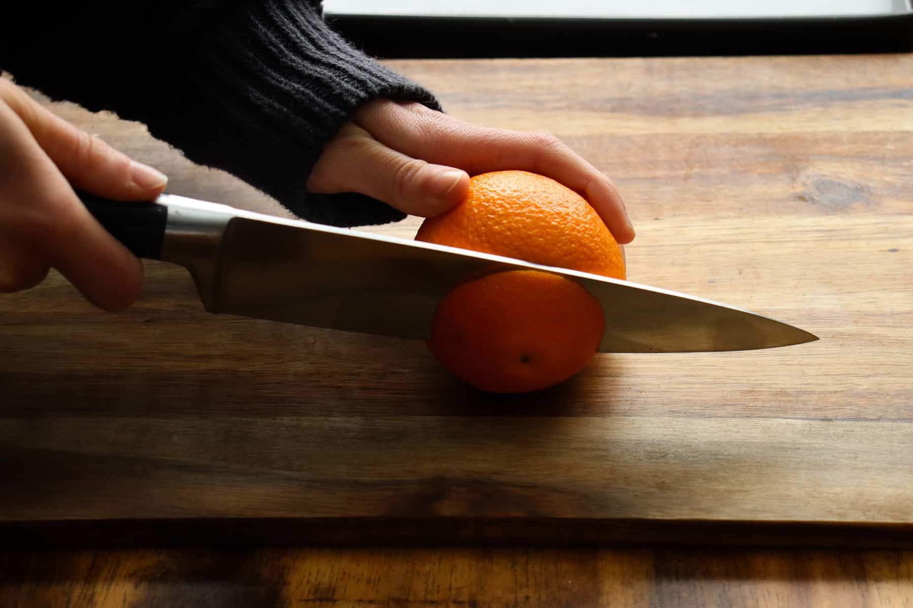 cutting the top of the orange off