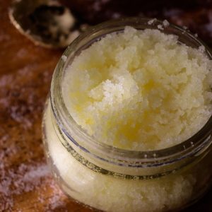 salt scrub in a glass jar with a small golden spoon nearby