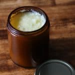 tallow balm in an amber glass jar with a gold lid