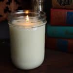 a tallow candle lit by a stack of books